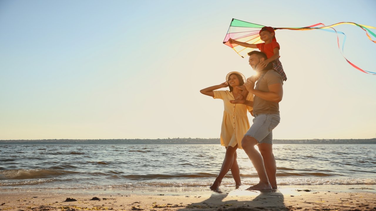 Famille jouant au cerf-volant sur la plage